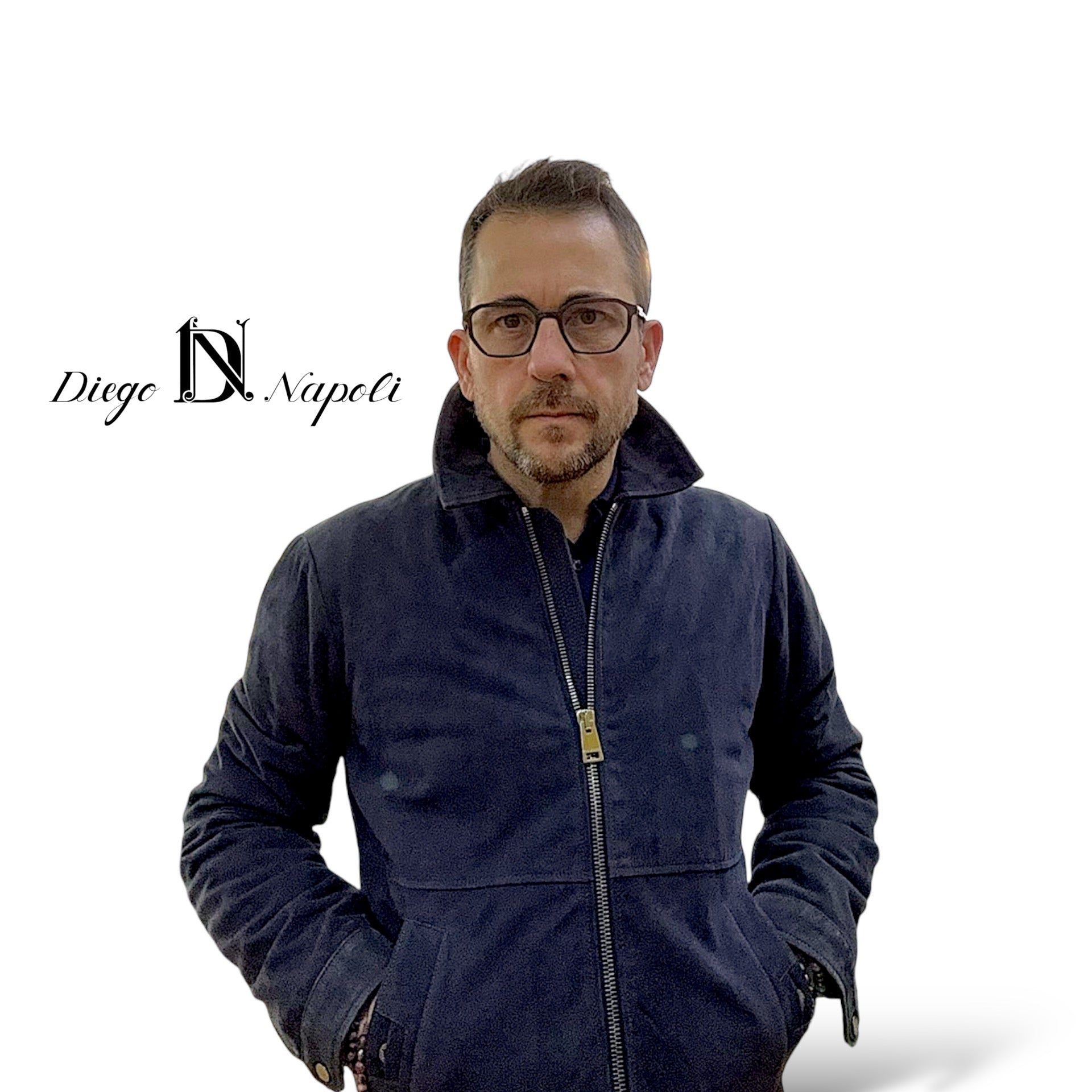 “Portrait d’un homme portant un blouson bleu marine de la marque Pal Zileri, associé à un polo en mérinos extrafin de la marque Diego Napoli. Le logo ‘Diego Napoli’ est visible en arrière-plan, ajoutant une touche d’élégance et d’authenticité à l’image.”